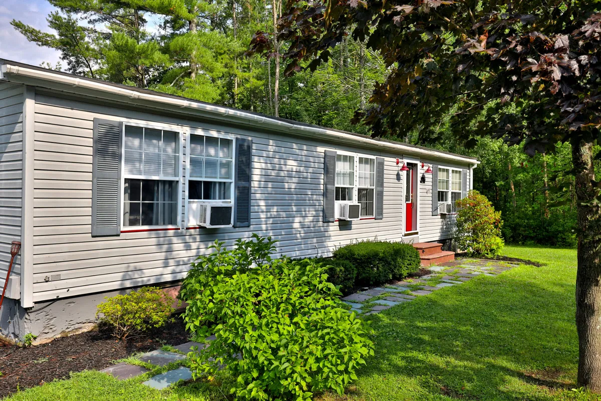 A welcoming exterior shot of the home, featuring the front door, large windows, and manicured landscaping. The image radiates a sense of invitation, with comfortable outdoor spaces designed for gatherings, relaxation, and enjoying sunsets from the porch or yard.