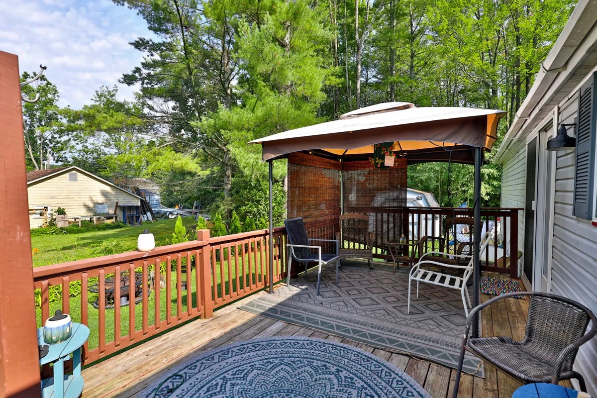 The photo features a tranquil garden view with a gazebo, comfortable seating, a decorative rug, and scenic outdoor surroundings. The setup invites guests to relax, socialize, and enjoy the peaceful setting, whether it's for morning coffee or family gatherings.